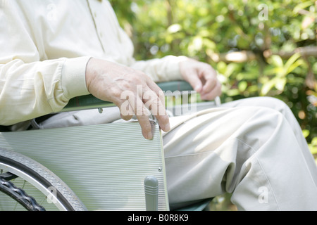 Man sur fauteuil roulant dans parc, mid section Banque D'Images