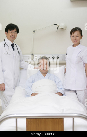 Portrait d'hommes et de femmes médecins au lit du patient Banque D'Images