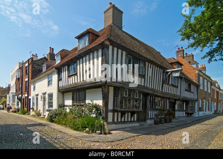 Grand angle horizontal de la belle Tudor cottages en place de l'église de seigle sur une journée ensoleillée. Banque D'Images