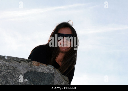 Jeune modèle portrait sur la clôture en pierre dans les falaises de Cedeira, La Corogne, Espagne. Banque D'Images