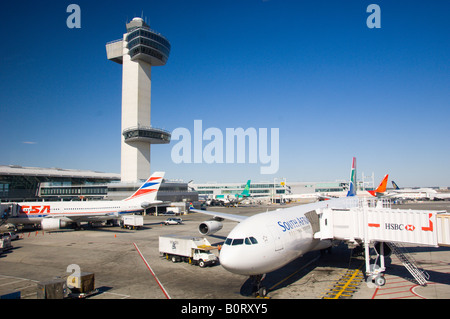 Le JFK International airport tour de contrôle du trafic aérien avec des avions garé au terminal Banque D'Images