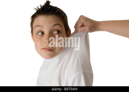 Naughty boy child chauds a saisi par le col d'avis pris dans la loi traînés par la discipline de comportement chemise détention à s Banque D'Images