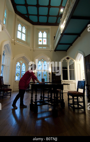 Une femme de poussières dans le Grand Hall de Chiddingstone Château près de Tunbridge Wells Kent lorsqu'il est ouvert au public. Banque D'Images