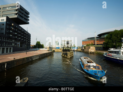 Nouveau bâtiment à Amsterdam Noord Bateau de tourisme dans la Westerdok patrouilleur de la police néerlandaise Banque D'Images