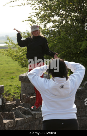 Deux touristes canadiens posent pour les photos sur un mur dans la vallée de la Boyne république d'Irlande Banque D'Images