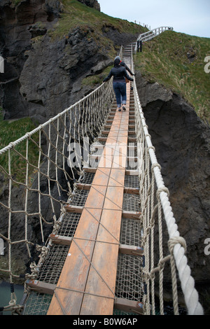 Deux femmes touristes traversant la carrick a rede Rope Bridge sur le comté d'Antrim Coast Irlande du Nord Banque D'Images