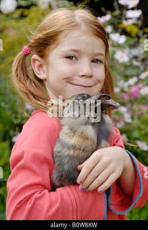 Little girl holding a Lapin Européen (Oryctolagus cuniculus) Banque D'Images