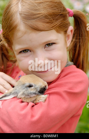 Little girl holding a Lapin Européen (Oryctolagus cuniculus) Banque D'Images