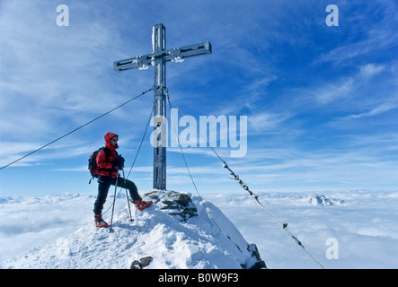 D'alpiniste debout sur le sommet du Mt. Similaun à côté d'un fer à repasser sommet cross, Tyrol, Autriche, Europe Banque D'Images