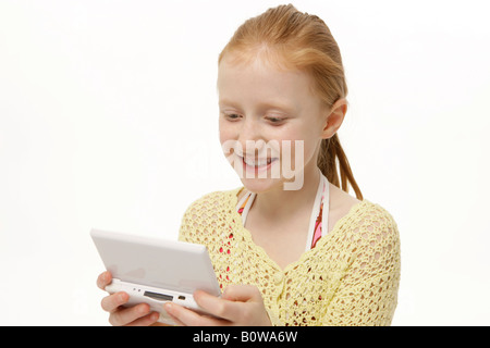 8-year-old girl playing Gameboy Banque D'Images