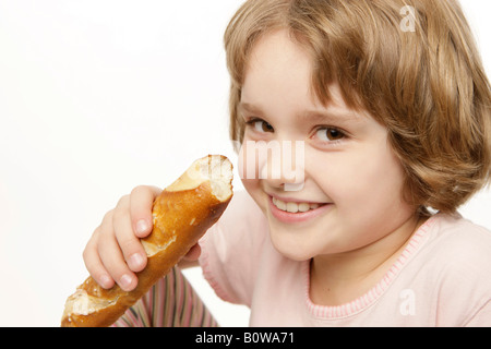 8-year-old girl eating une baguette Banque D'Images