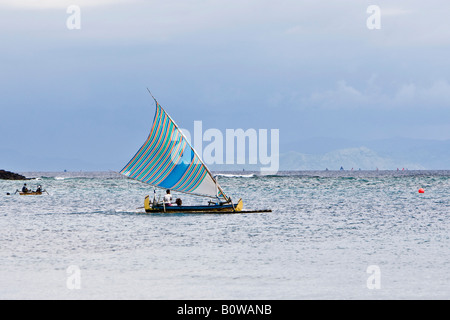 Bateau de pêche traditionnel de mettre les voiles au large de la côte de l'île de Lombok, Indonésie, Îles de la sonde Lesser Banque D'Images