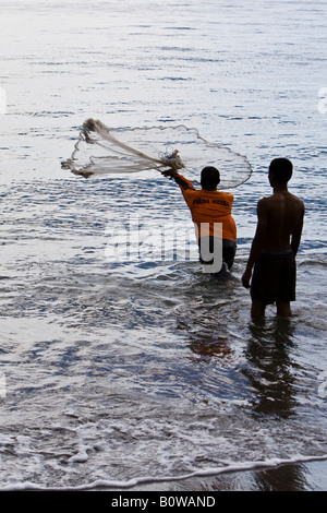 La mer pêcheur debout dans son casting net, île de Lombok, Indonésie, Îles de la sonde Lesser Banque D'Images