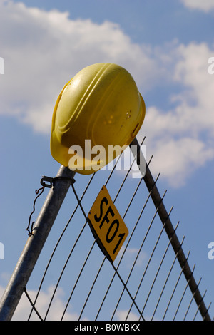 Casque jaune situé sur chantier clôture, Stuttgart, Germany, Europe Banque D'Images