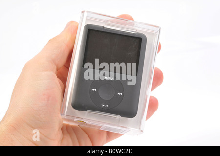 Hand holding Apple iPod Nano, noir, dans son emballage d'origine Banque D'Images