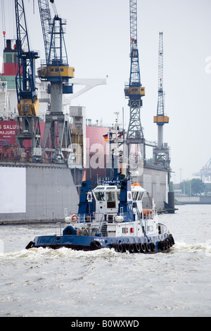 Bateau-pilote bleu sur l'Elbe au port d'Hambourg, en passant par les porte-conteneurs dry dock Banque D'Images