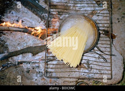 Spaghetti dans une casserole d'eau bouillante sur un feu de camp Banque D'Images