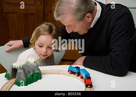 Un grand-père et petit-fils de jouer avec un petit train set Banque D'Images