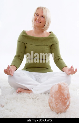 Femme blonde avec une lampe de sel, faire du yoga Banque D'Images