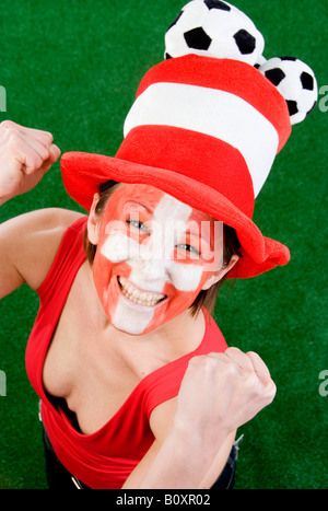 Cute woman with red top et chapeau en tant que fan de la Suisse, ils applaudissent avec les poings serrés Banque D'Images