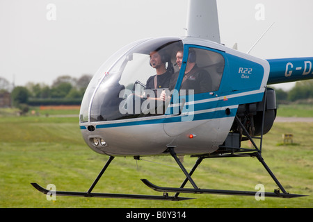 Robinson R-22 Beta G-DAAM Vol hélicoptère en close-up de cockpit pilote & passager montrant Banque D'Images