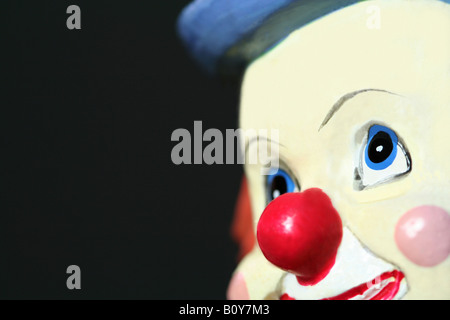 Un jouet le visage de clown sur un fond sombre Banque D'Images