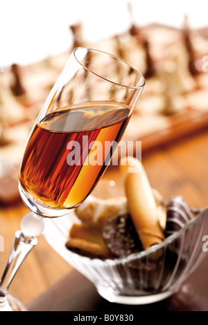 Un verre de sherry à côté d'un bol avec les cookies Banque D'Images