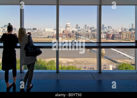 Grand angle horizontal de filles en profitant de la vue à travers une grande fenêtre de Londres vers la Cathédrale St Paul sur une journée ensoleillée. Banque D'Images