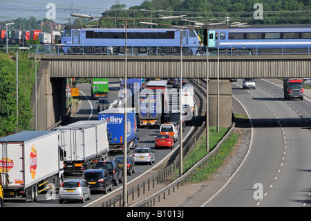 Transport choix autoroute M 25 congestion lent circulation en mouvement confiture regardant la rapide de train de voyageurs pont de chemin de fer sortie 28 Brentwood Essex Angleterre Royaume-Uni Banque D'Images