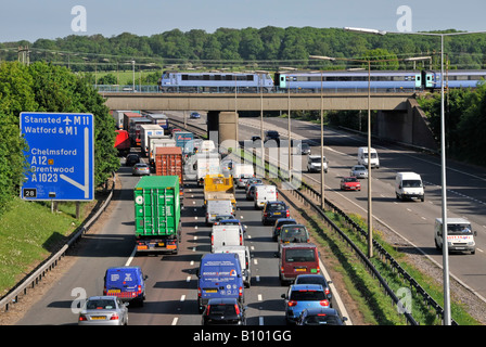 Transport choix autoroute M 25 congestion lent circulation en mouvement confiture regardant la rapide de train de voyageurs pont de chemin de fer sortie 28 Brentwood Essex Angleterre Royaume-Uni Banque D'Images