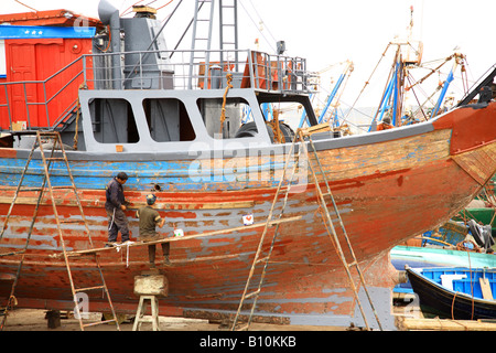 La réparation des travailleurs d'un bateau dans le port d'Essaouira Maroc Banque D'Images