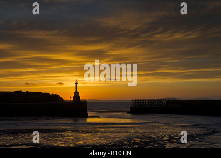 Coucher de soleil derrière le phare et le port à Maryport, Cumbria, Angleterre, Royaume-Uni Banque D'Images