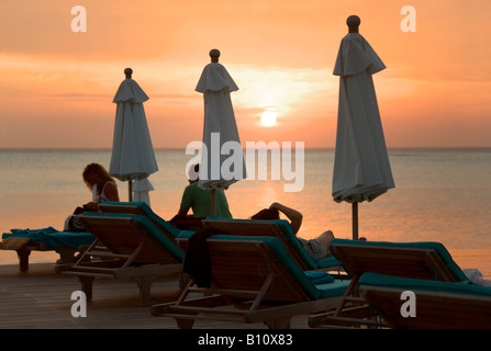 Coucher de soleil sur la piscine à débordement et le lagon de Anantara Resort aux Maldives Banque D'Images