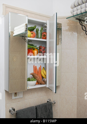 Accueil à l'armoire à pharmacie dans la salle de bain rempli de fruits et légumes frais nutitious Banque D'Images