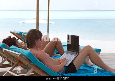 Travailler sur un ordinateur portable dans les Maldives côté piscine Banque D'Images