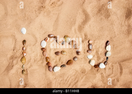 Je vous aime écrit comme 'i heart u' en pierres sur le sable Banque D'Images