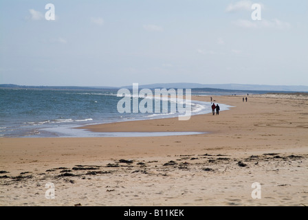 dh Mer du Nord côte bord de mer DORNOCH FIRTH SUTHERLAND ÉCOSSE couple marchant sur la plage de sable personnes sable rivage plages écossaises marche Banque D'Images