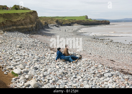 L'homme et la femme assise sur la plage de galets, Kilve, Somerset, England, UK Banque D'Images