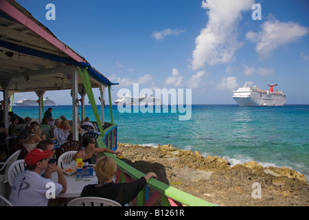 Restaurant en plein air sur le front de mer de Georgetown sur Grand Cayman dans les îles Caïmans dans les Caraïbes avec des bateaux de croisière en backgrd Banque D'Images