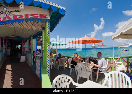 Restaurant en plein air sur le front de mer de Georgetown sur Grand Cayman dans les îles Caïmans dans les Caraïbes avec des bateaux de croisière en backgrd Banque D'Images