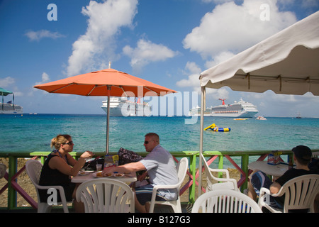 Restaurant en plein air sur le front de mer de Georgetown sur Grand Cayman dans les îles Caïmans dans les Caraïbes avec des bateaux de croisière en backgrd Banque D'Images