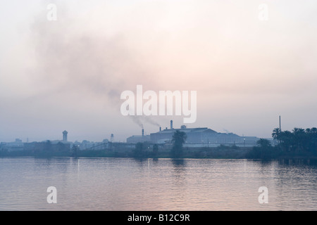 La pollution industrielle de l'usine sur les rives du Nil à l'aube du pont du Nile Cruiser, Louxor, vallée du Nil, l'Egypte Banque D'Images