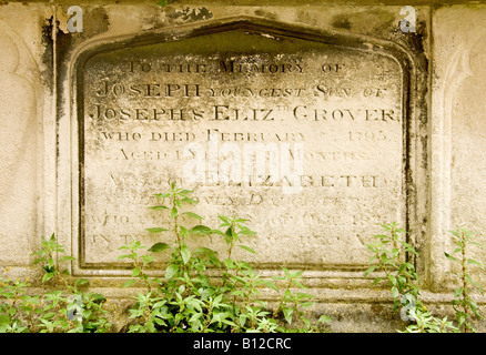 Pierre géorgienne tombe pierre tombale envahie par les mauvaises herbes dans un cimetière de l'église dans l'East Sussex Lewes Banque D'Images