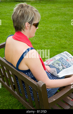 Femme lisant le Racing Post, avant réunion de courses à l'hippodrome de Perth, Écosse, Royaume-Uni Banque D'Images