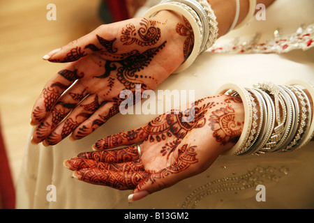 Mariée indienne le jour de son mariage avec ses mains habillées traditionnellement décorées dans le henné Banque D'Images