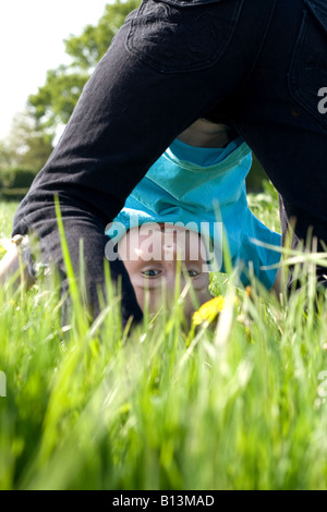 Young boy doing handstand in champ d'été Banque D'Images