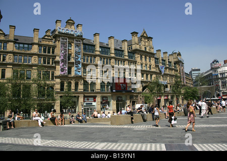 Ville de Manchester, en Angleterre. Consommateurs et aux touristes profitant du soleil à Exchange Square avec le triangle dans l'arrière-plan. Banque D'Images