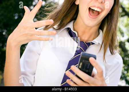 Girl choqué à la réception du message sur le téléphone Banque D'Images