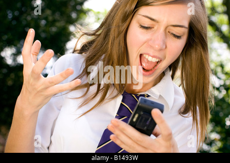 Girl choqué à la réception du message sur le téléphone Banque D'Images
