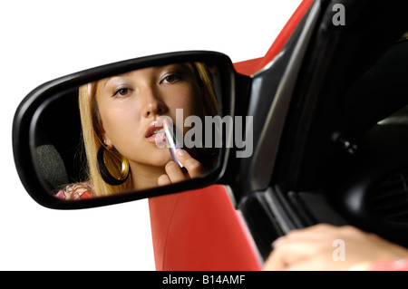 Woman applying lipstick dans une voiture Banque D'Images